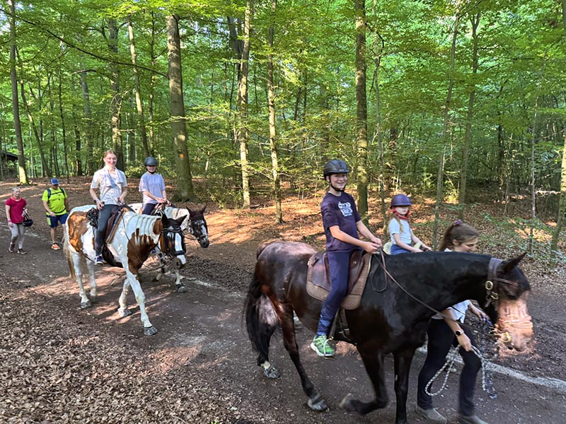 Kinder reiten durch den Wald